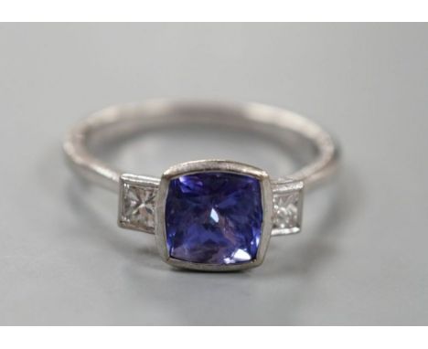 A modern 18ct white gold, single stone tanzanite and two stone diamond set ring, size R, gross weight 5 grams.