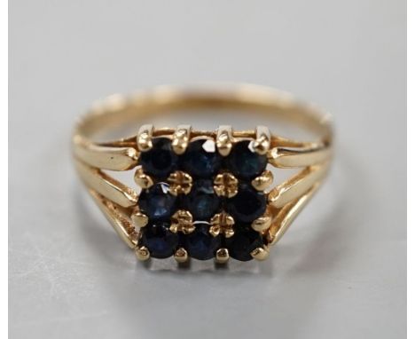 A modern 9ct gold and nine stone sapphire set tablet ring, size R/S, gross weight 2.7 grams.