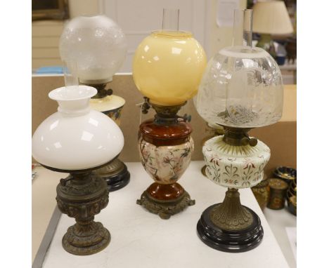 A Doulton style pottery oil lamp and four other glass and brass oil lamps, tallest 54 cms including glass shade.