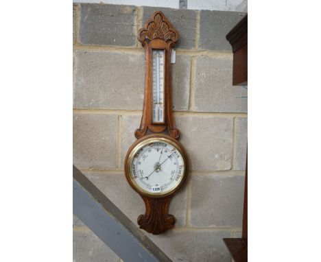 A late Victorian carved oak aneroid barometer and thermometer, height 84cm
