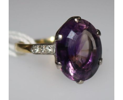 An 18ct gold and amethyst dress ring with diamond set shoulders, size K.