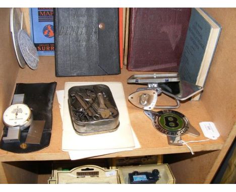 A collection of motoring memorabilia including the Bentley Drivers Club badge, a handbook for a Bentley 4.4 mark VI, together