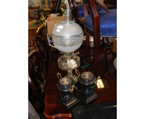 A Victorian oil lamp with glass reservoir, together with a pair of black slate urns
