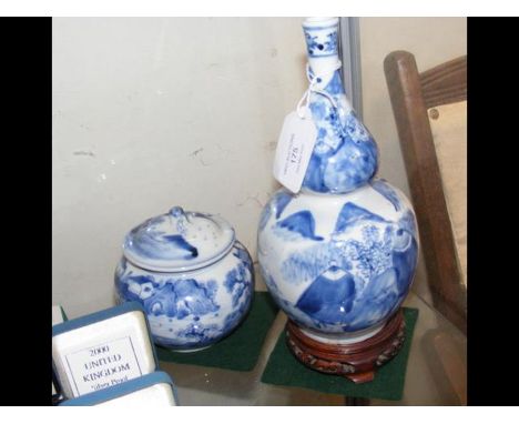 An antique Chinese blue and white gourd vase with character mark to base - 20cm high - on wooden stand, together with a blue 