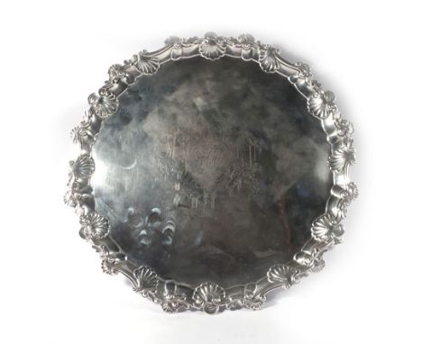A George III silver salver of circular form having shell and scalloped border on three claw and ball feet, maker (?)IM, Londo