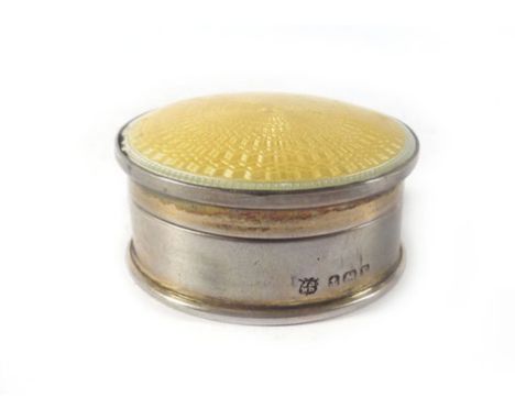 An early 20th century silver and guilloché enamelled pill/powder container of circular form decorated in a pale yellow enamel