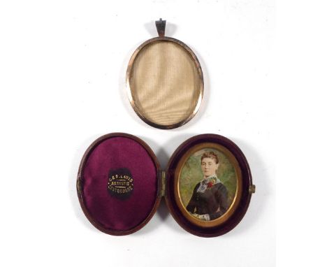 A 19th century miniature overpainted head and shoulders portrait in a fitted leather case, 6.5 x 5 cm, together with a silver