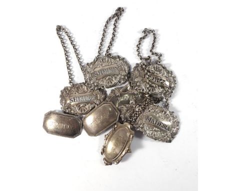 An early 19th century silver decanter label for 'Port' repousse decorated with a putti seated on a fruiting vine, w. 6.5 cm, 