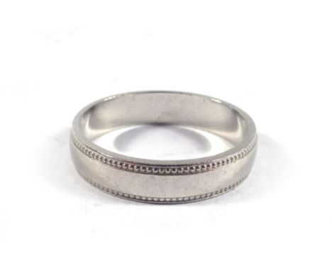 A platinum wedding band having beaded decoration, ring size K,3.8 gms