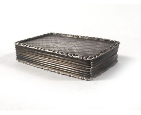 A Victorian silver and parcel gilt vinaigrette of rectangular form decorated with checkered engraving within a scrollwork bor