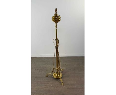 ART NOUVEAU PARAFFIN BRASS STANDARD LAMP,converted to electricity, raised on three outswept supports, the weighted base stamp