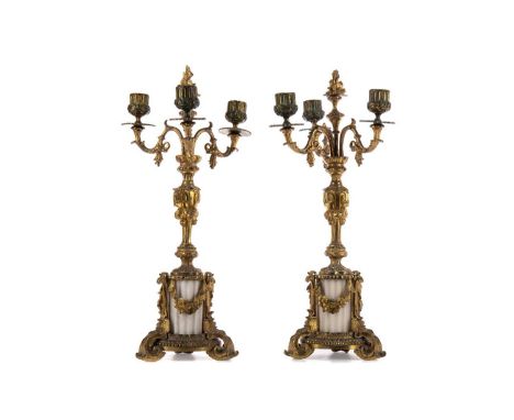 PAIR OF CAST GILT METAL AND ALABASTER TWIN-BRANCH CANDELABRA,each with foliate detail, over a fluted column base on three scr