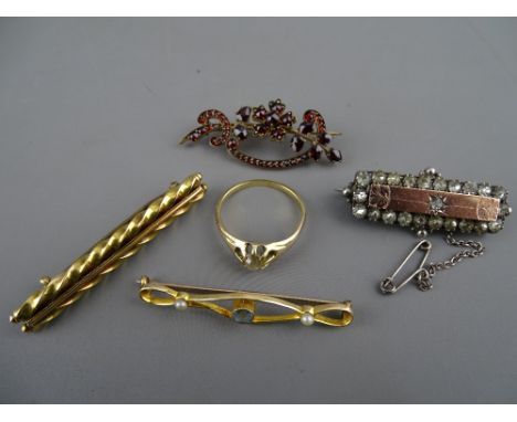 Four Victorian bar brooches in fifteen carat gold and other metals, one having garnet type settings and a presumed gold diamo
