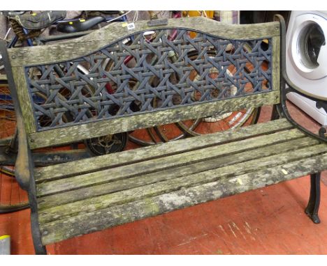 Wooden garden bench with cast metal ends and latticed back