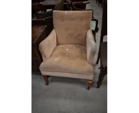 A late 19th or early 20th Century low seat armchair having button seat and back