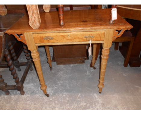A late 19th early 20th C light oak side table fitted with single frieze drawer with Gothic style brass swing handles and rais