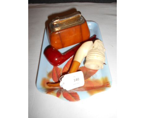 A bone and amber Meerschaum pipe, a cherry amber pipe and a Colibri Monpol amber cased table lighter