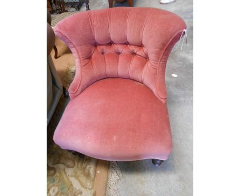 A Victorian button-back bedroom chair with serpentine seat and raised on turned supports and castors