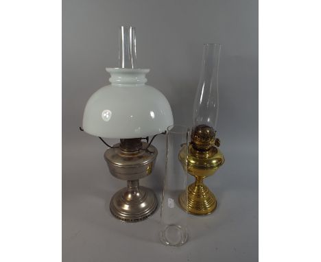 A Brass Oil Lamp Together with a Chromed Example and Spare Glass Chimney  