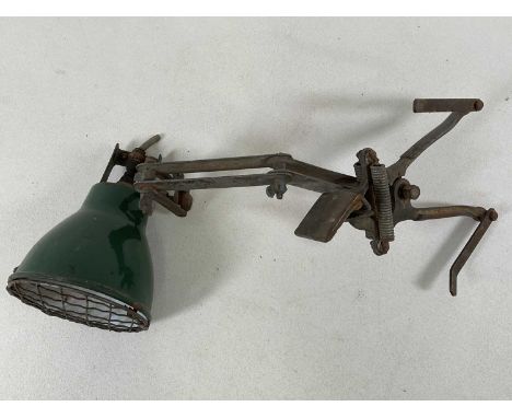 An industrial machinist's workbench adjustable lamp, with green enamel shade with mesh cover mounted to a sprung lever clamp.