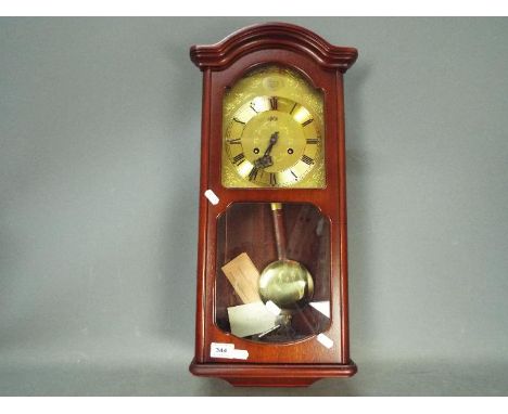 A modern, mahogany cased, AMS wall clock with key and pendulum.