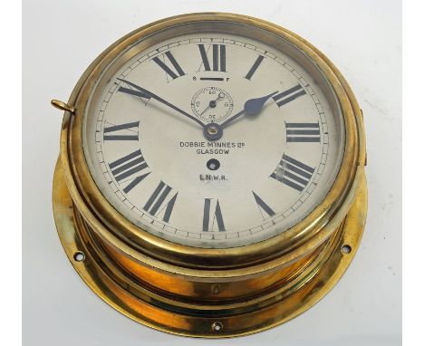 A 1920s brass, ship's bulkhead clock, by Dobbie McInnes Ltd., Glasgow, for TSS Scotia, the silvered dial, with Roman numerals