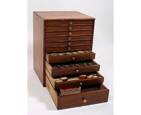 A watchmaker's cabinet of watch parts. A pine tabletop cabinet of ten graduated drawers containing a watchmaker's stock of wa