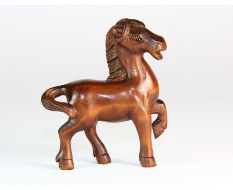 A carved fruit wood horse netsuke with onyx eyes H 6cm