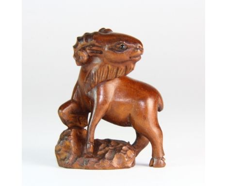 A carved fruitwood goat netsuke with onyx eyes H 5cm