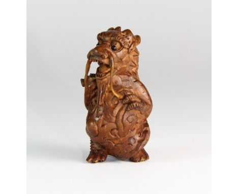 A carved fruit wood dragon netsuke with onyx eyes H 5cm