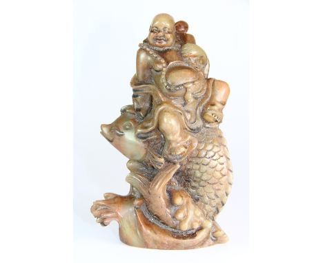 An unusual large carved Chinese hardstone seal of the happy Buddha riding a fish above a wave H 15cm