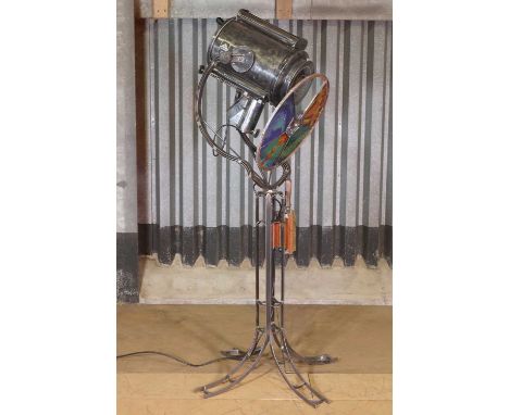 A theatre spotlight lamp,c.1930s and later, with a rotating coloured glass wheel, raised on a pierced column and four feet, 5