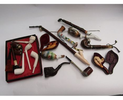 A selection of smoking pipes including carved and ceramic examples, carved dog looking at fly on its back 