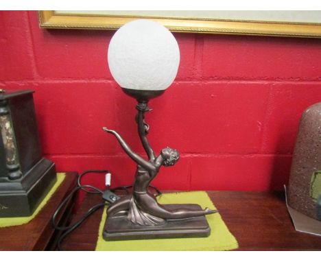 A modern table lamp in Art Deco style, semi-clad lady holding globular shade aloft 