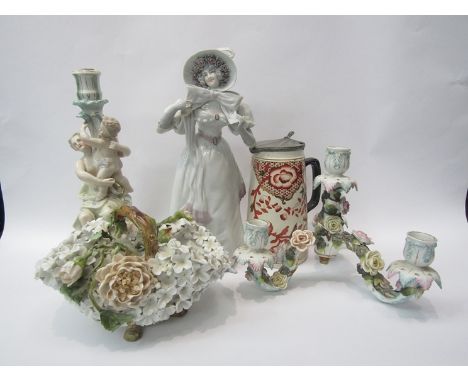 A porcelain figure of a Victorian lady wearing a bonnet, a ceramic candlestick of figural form, a floral basket and a jug wit