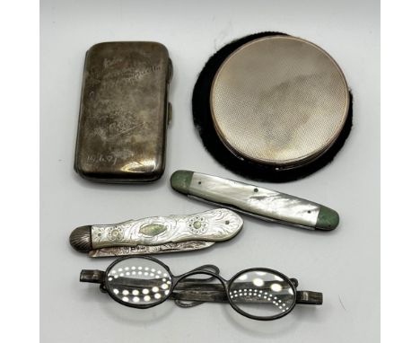 A George V silver compact, two silver and mother of pearl fruit knives, a cigarette case and a pair of spectacles 