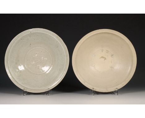 China, twee celadon en crème geglazuurde schalen, Noordelijke Song-dynastie, 10e-12e eeuw, met gekraagde rand, een bedekt met