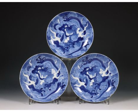 Japan, set van drie blauw-wit porseleinen Nabeshima-stijl 'draken' bordjes, 19e eeuw, elk gedecoreerd met een draak en wolken