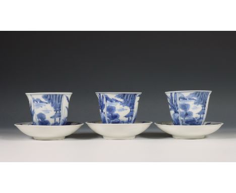 Japan, set van drie blauw-wit porseleinen koppen en schotels, 19e/ 20e eeuw, elk gedecoreerd met panelen met paviljoens en pl