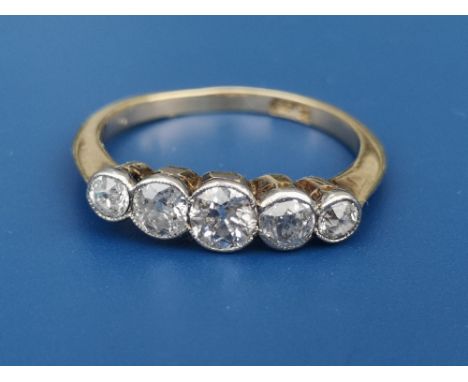 A graduated five stone old cut diamond ring in millegrain settings, the central stone weighing approximately 0.25 carat.   Fi