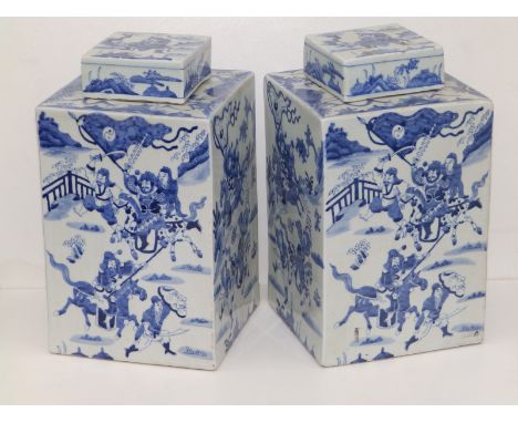 A pair of 20thC Chinese blue &amp; white porcelain square section covered vases, decorated with warriors in battle, bearing s