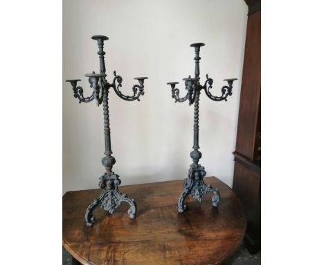 A pair of 19thC cast iron floor-standing triple branch candelabra in the baroque taste, 44" high.