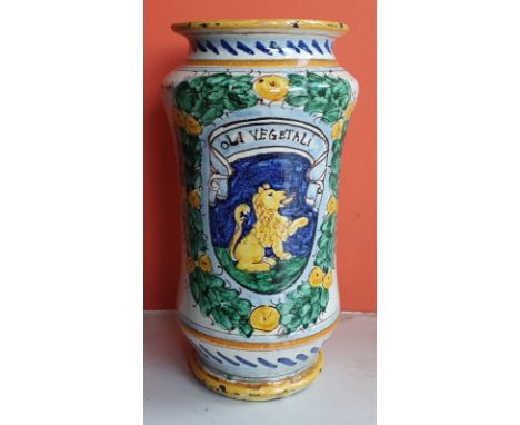 An antique pottery albarello of waisted form, decorated with a heraldic shield surrounded by a laurel wreath - 'Oli Vegetali'