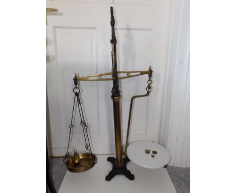 A tall set of brass &amp; cast iron balance scales on paw feet, with ceramic pan &amp; weights.