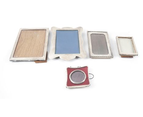 A SILVER AND FOIL BACKED RED COLOURED GLASS MOUNTED PHOTOGRAPH FRAME AND FOUR FURTHER SILVER MOUNTED PHOTOGRAPH FRAMES (5)The