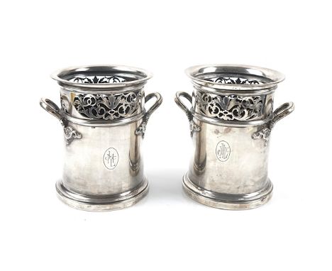 TWO SIMILAR SILVER TWIN HANDLED BOTTLE STANDS (2)Each with scroll pierced decoration, on a circular loaded base, height 16cm,