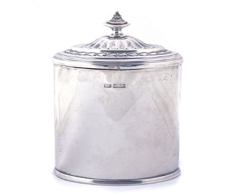 A SILVER HINGE LIDDED TEA CADDYOf oval form, the lid with partly fluted decoration, with a foliate border and with an urn sha