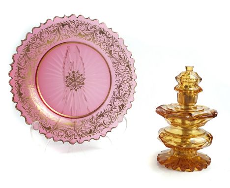 TWO ITEMS OF COLOURED GLASSLate 19th centuryThe first a ruby glass plate with gilt foliate border and star cut base, 22cm dia