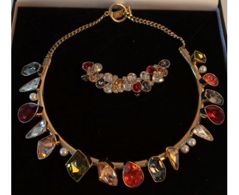 A GILT METAL VARICOLOURED SWAROVSKI CRYSTAL AND IMITATION PEARL COLLAR NECKLACE AND AN EAR CUFF (2)The curved gilt metal coll