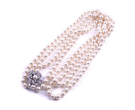 A TWO ROW NECKLACE OF CULTURED PEARLSOn a white gold, diamond and cultured pearl clasp, designed as a flowerhead, detailed 58